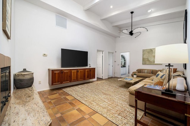 living room with beamed ceiling, a notable chandelier, and a towering ceiling