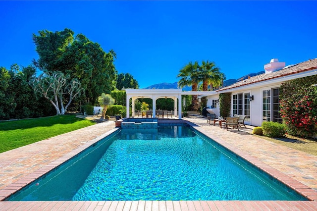 view of pool with a lawn, a patio area, and an in ground hot tub