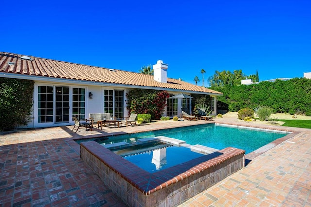 view of swimming pool featuring a patio area and an in ground hot tub