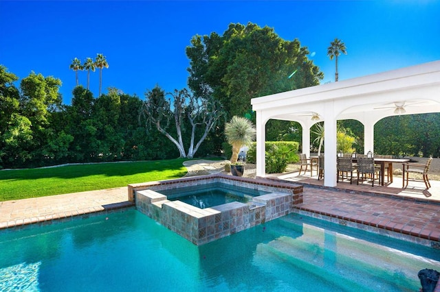 view of swimming pool with an in ground hot tub, a patio, ceiling fan, and a lawn