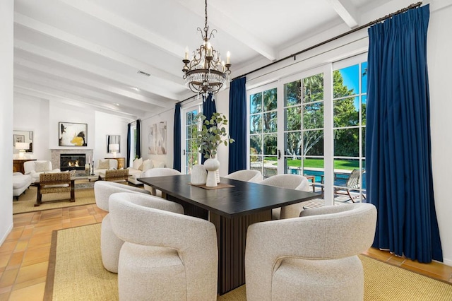 dining space with plenty of natural light, light tile patterned floors, a high end fireplace, and an inviting chandelier