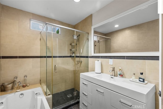 bathroom with plus walk in shower, vanity, and tile walls