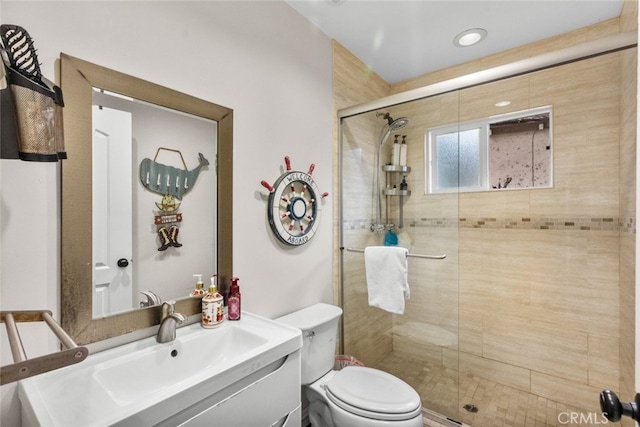 bathroom featuring vanity, toilet, and walk in shower