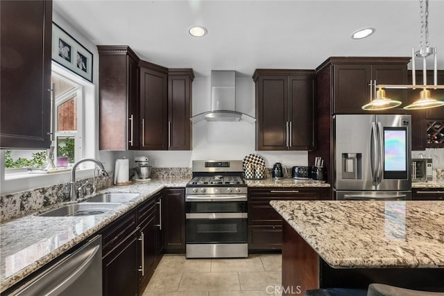 kitchen with appliances with stainless steel finishes, sink, wall chimney range hood, hanging light fixtures, and light tile patterned flooring