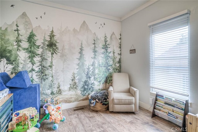 sitting room featuring ornamental molding, plenty of natural light, and light hardwood / wood-style floors