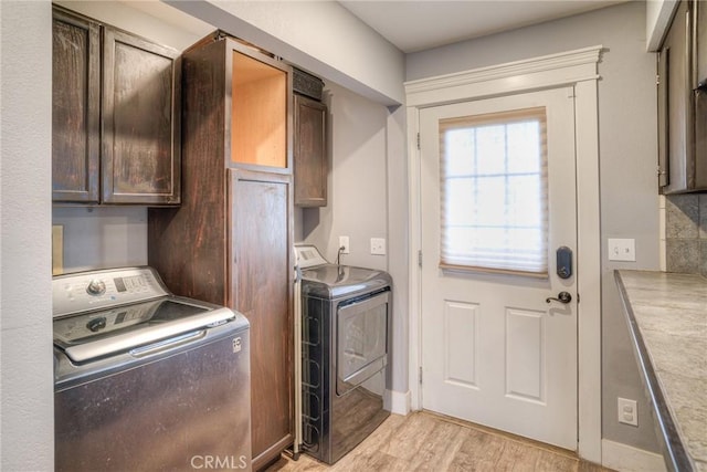 laundry room featuring cabinets, washer and dryer, and light hardwood / wood-style floors