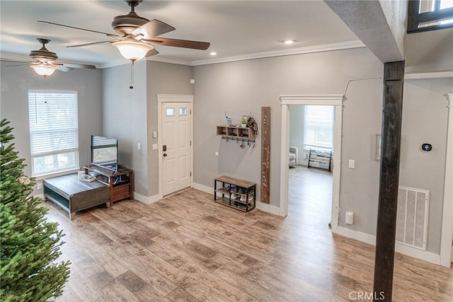 foyer entrance featuring ornamental molding and light hardwood / wood-style flooring