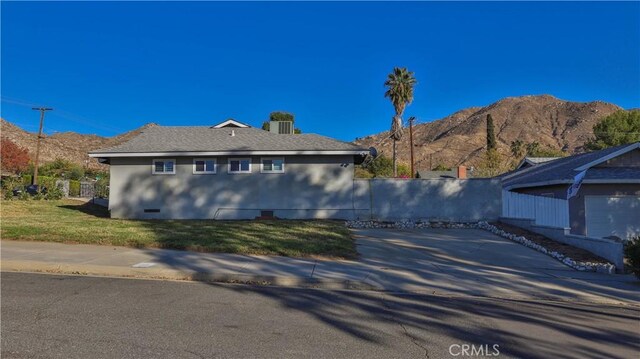 view of side of home featuring a mountain view and a yard