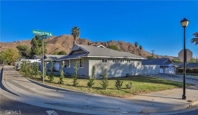 view of property exterior with a mountain view and a yard