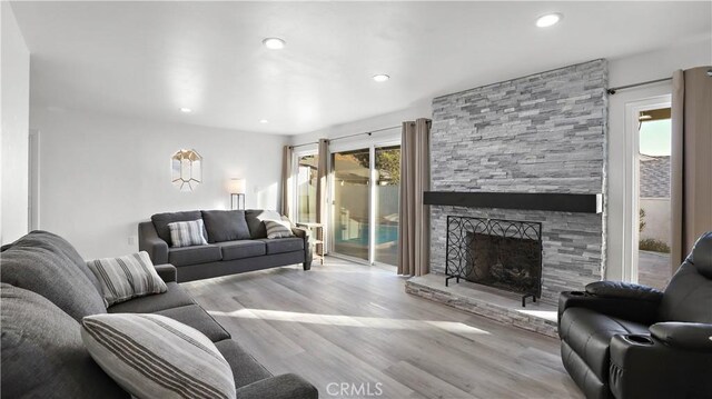 living room with a fireplace and light wood-type flooring