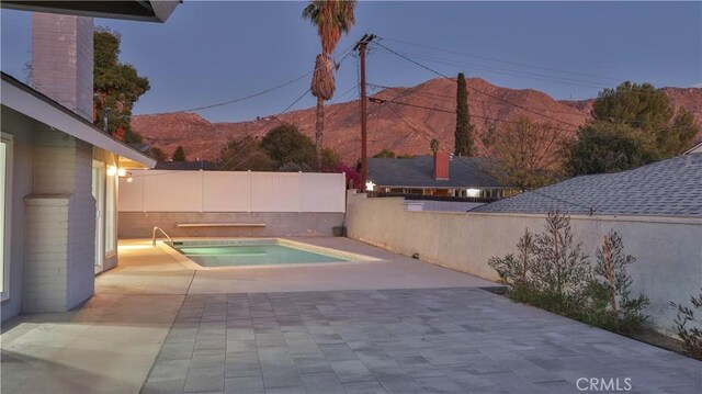 view of pool with a mountain view, an in ground hot tub, and a patio area