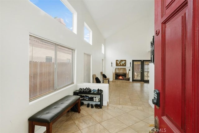 foyer with light tile patterned floors, high vaulted ceiling, and french doors