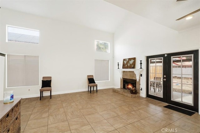 interior space featuring a tiled fireplace, french doors, a towering ceiling, and light tile patterned floors