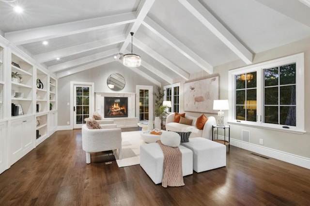 living room featuring lofted ceiling with beams, a healthy amount of sunlight, and dark wood-type flooring