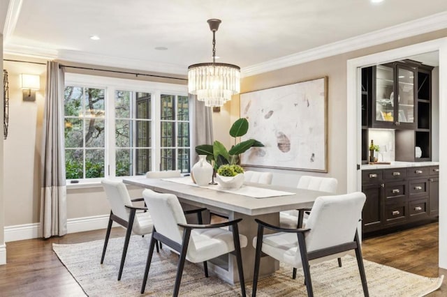 dining space with crown molding, dark wood-type flooring, and a notable chandelier