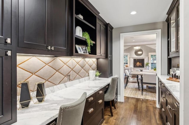 kitchen featuring light stone counters, decorative backsplash, and dark hardwood / wood-style floors