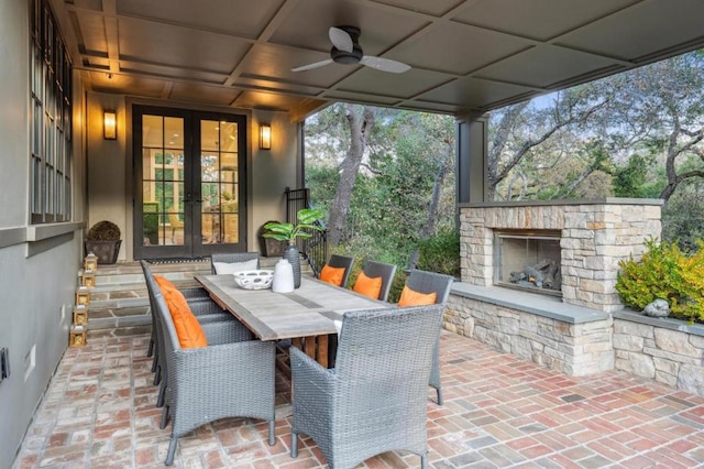 view of patio featuring ceiling fan, an outdoor stone fireplace, and french doors