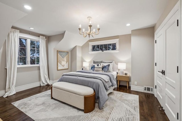 bedroom with an inviting chandelier and dark hardwood / wood-style flooring