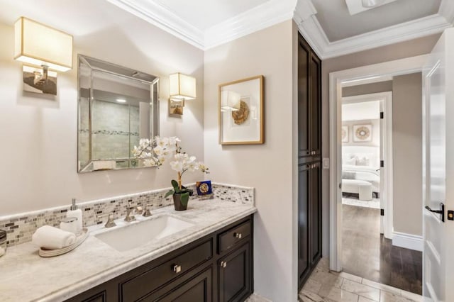 bathroom with crown molding, vanity, and decorative backsplash