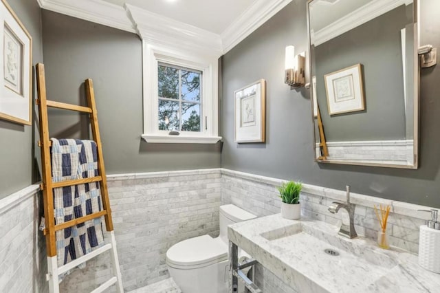 bathroom with tile walls, sink, ornamental molding, and toilet