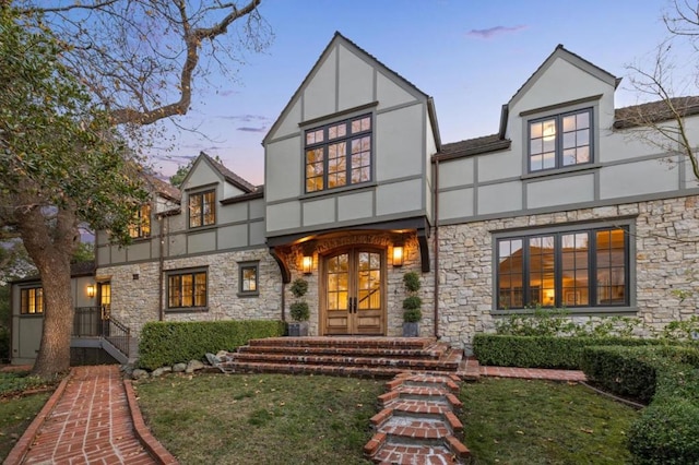 view of front of property with a yard and french doors