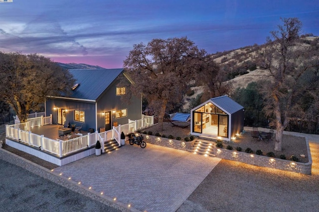 view of front of home featuring a mountain view, a patio area, and an outbuilding