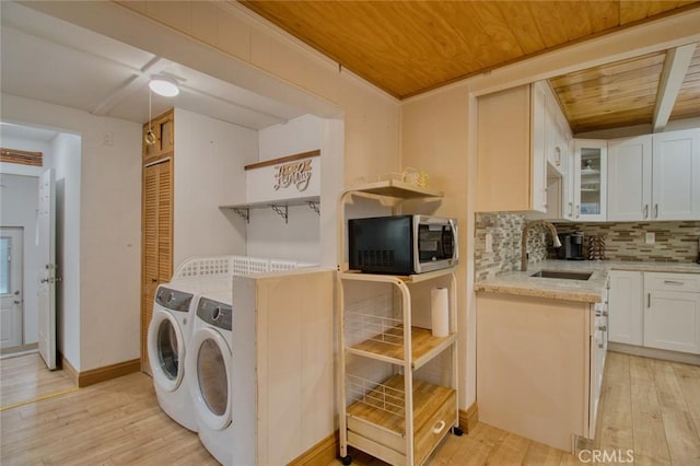 washroom featuring separate washer and dryer, sink, wood ceiling, and light hardwood / wood-style flooring