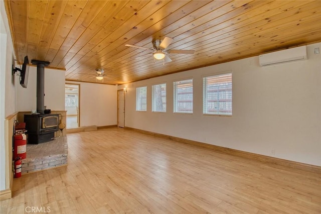 unfurnished living room featuring wood ceiling, light wood-type flooring, a wood stove, an AC wall unit, and ceiling fan