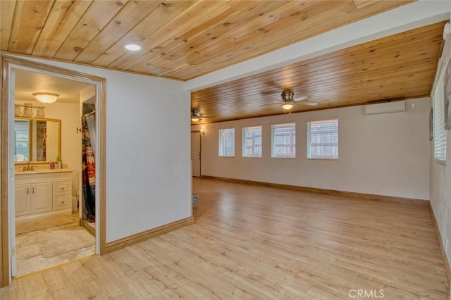 spare room with ceiling fan, wooden ceiling, a wall unit AC, and light wood-type flooring