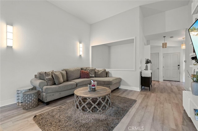 living room featuring light hardwood / wood-style floors and high vaulted ceiling