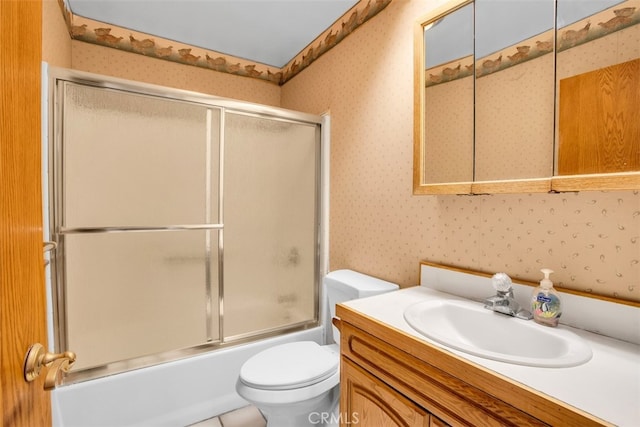 full bathroom featuring vanity, toilet, and bath / shower combo with glass door