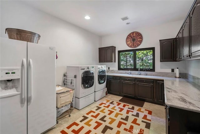 washroom featuring washer and clothes dryer, cabinets, and sink