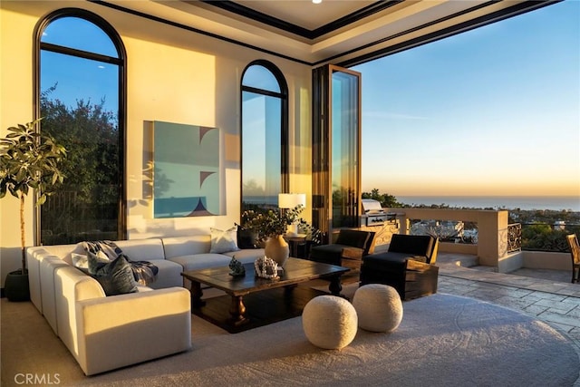 patio terrace at dusk with an outdoor living space and a water view