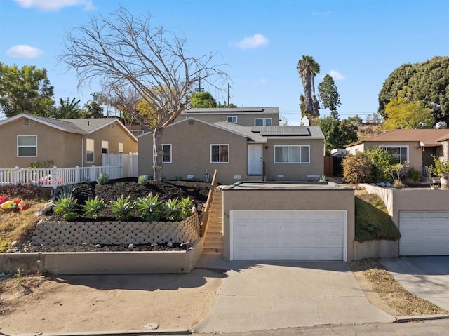 view of front of property with a garage and solar panels