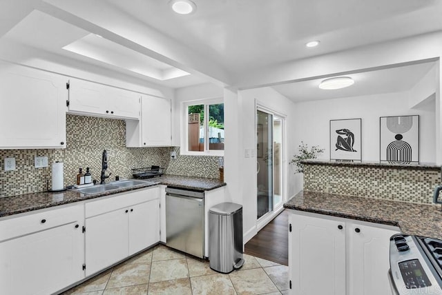 kitchen with backsplash, white cabinets, and appliances with stainless steel finishes