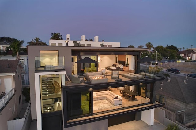 back house at dusk featuring outdoor lounge area