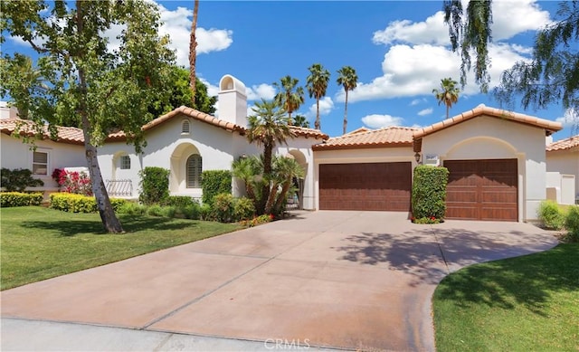 mediterranean / spanish home featuring a garage and a front lawn