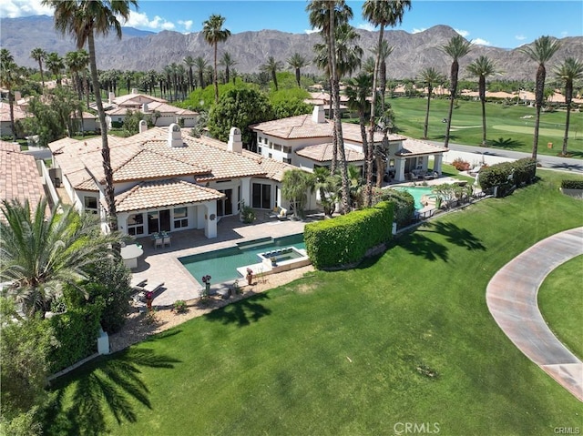 view of swimming pool featuring a patio area, a yard, and a mountain view