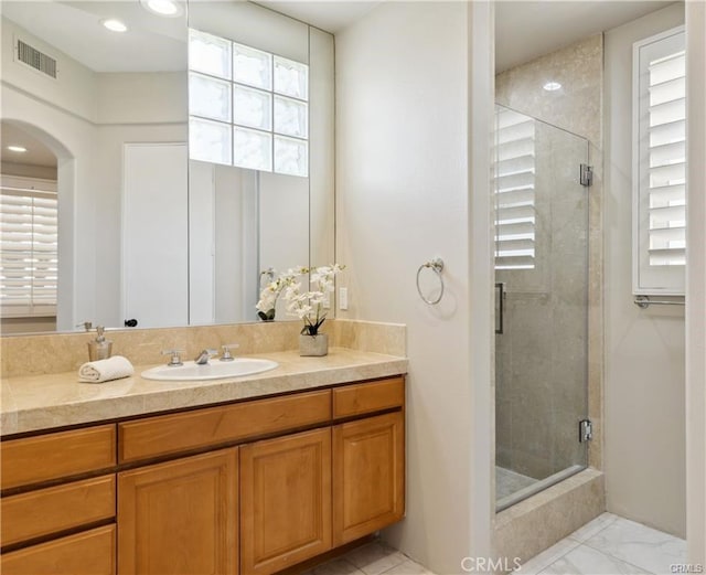 bathroom with walk in shower and vanity