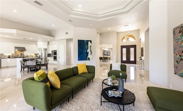 living room featuring french doors and a tray ceiling