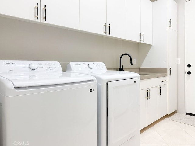 washroom featuring sink, cabinets, washing machine and clothes dryer, and light tile patterned floors