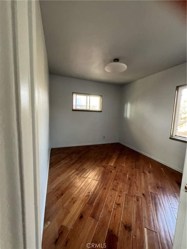 unfurnished room with hardwood / wood-style flooring and a healthy amount of sunlight