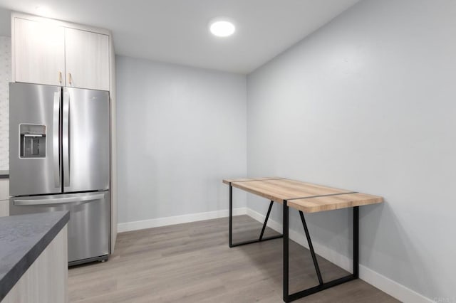 kitchen featuring light wood-type flooring and stainless steel fridge