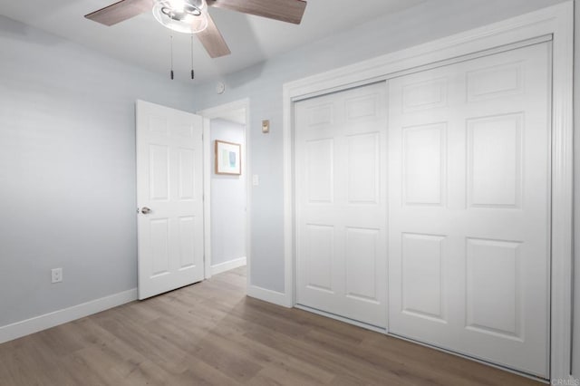 unfurnished bedroom with ceiling fan, a closet, and light hardwood / wood-style flooring