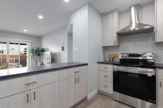 kitchen with electric stove, backsplash, light wood-type flooring, and wall chimney exhaust hood