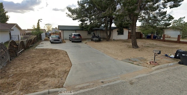 view of front of property featuring concrete driveway and fence