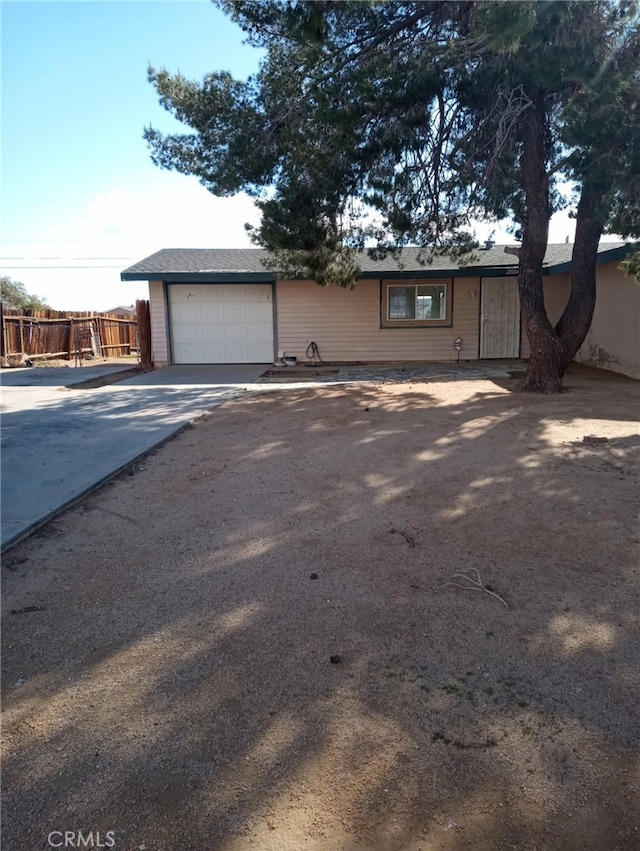 ranch-style house with driveway, a garage, and fence