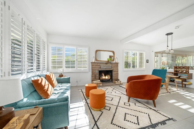 tiled living room featuring a fireplace, beamed ceiling, and a healthy amount of sunlight