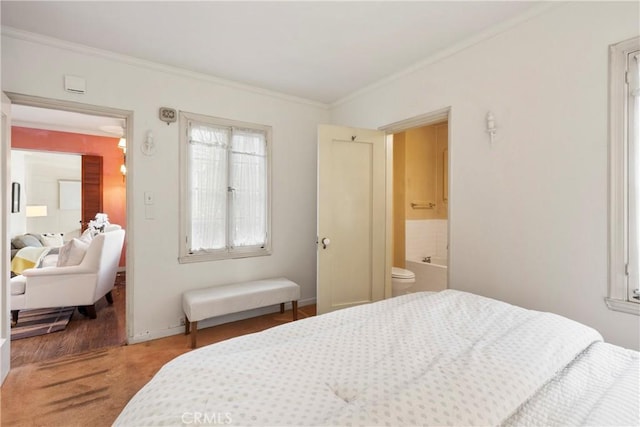 bedroom with ornamental molding and ensuite bathroom