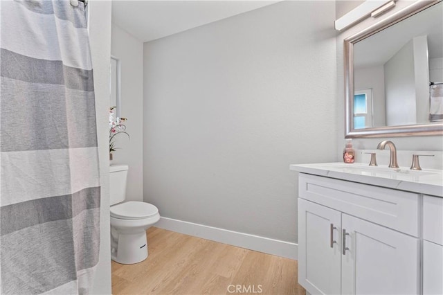 bathroom featuring vanity, hardwood / wood-style flooring, and toilet